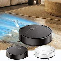 two robotic vacuums sitting on the floor next to each other