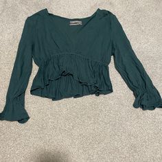 Cropped Dark Green Urban Outfitters Peplum Top. Super Cute And Comfy. Peplum Also On The Sleeves. Deep V Neck And Long Sleeves. Never Worn And Great Condition. Price Negotiable. Last Picture Is The Picture On The Model And The Second Photo Shows The Color The Best. No Rips Of Flaws. Size Medium. Bohemian V-neck Top With Ruffle Hem, Spring Long Sleeve Tops With Ruffle Hem, Spring Long Sleeve Peplum Top With Ruffle Hem, Summer Tops With Ruffle Hem And Long Sleeves, Spring Long Sleeve Peasant Top With Ruffle Hem, Long Sleeve Blouse With Ruffle Hem For Brunch, Fall Peplum Top With Ruffle Hem, Fitted Long Sleeve Peplum Top For Summer, Long Sleeve Ruffle Peplum Top For Brunch