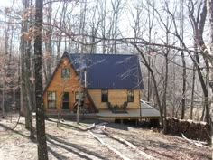 a log cabin in the woods surrounded by trees