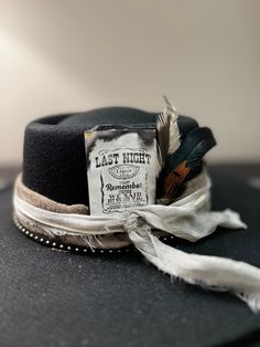 "Last night we let the liquor talk...\" Morgan Wallen fans - this hat is for you. The card with lyrics is removable however, so you can wear this black wide rim fedora anytime to any event. This is a 100% wool round crown hat with a 15\" wide brim. It is adorned with a silk scarf, cream and gold ribbon black,  leather band studded with gold beads.  Also is one single rooster feather! The perfect neutral, black, wide brim Lainey Wilson style hat! . SIZE: Fedora Hat is OSFA Wired brim measuring 3 3/4\" and a crown height of 4 3/4\". The Fedora Hat has a adjustable band with drawstring which allows for a perfect fit. Materials: This hat is made from a blend of 65% cotton and 35% polyester, providing a comfortable and durable construction. It also includes a faux leather band, suede cord, and Black Curved Brim Hat For Themed Events, Vintage Black Top Hat For Western-themed Events, Black Top Hat For Kentucky Derby And Country Events, Black High Crown Top Hat For Western-themed Events, Black High Crown Felt Hat For Western-themed Events, Black Felt Hat With High Crown For Western-themed Events, Black Felt Hat For Western-themed Events, Custom Black Hat For Party, Lainey Wilson Style