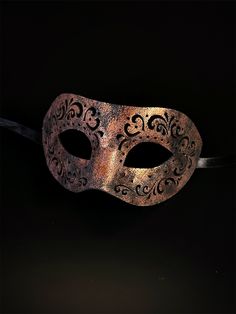 Crafted with intricate engraved patterns on soft vegan leather, this mask is a masterpiece of artistry that adds an air of mystique to your masquerade ensemble. Embrace the allure of engraved elegance and captivate hearts with your enigmatic presence at masquerades and special events! Age Group/Gender - Adult/Men Size/Type - One size fits all adults Mask Color - Copper Mask Material - Vegan Leather Gothic Adjustable Masquerade Mask, Venetian Formal Eye Mask, Adjustable Mask For Masquerade, Formal Venetian Eye Mask For Masquerade, Venetian Masquerade Mask For Halloween Formal, Venetian Style Formal Eye Masquerade Mask, Elegant Eye Mask For Theater, Elegant Theater Eye Mask, Vintage Mask For Party