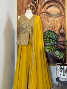 A majestic, exclusive readymade yellow Palazzo/Sharara with heavy embroidered jacket style top. in a beautiful colour.It is stitched and ready to wear. Perfect Indian Party wear, Indo western dress. Details Sharara/Palazzo Fabric: Georgette Inner : Crape lined Design: Plain with Huge Flair Jacket Top Fabric: Georgette Inner : Crape lined Design: Sleeveless v neck with heavy embroidery with stylish buttons on the front Dupatta Fabric : Georgette Design : Designer dupatta with lace edging on all f Yellow Unstitched Sharara For Transitional Season, Yellow Sets With Gota Work For Transitional Season, Yellow Sets With Gota Work For Seasonal Transition, Transitional Yellow Sets With Gota Work, Elegant Yellow Palazzo Set With Traditional Drape, Yellow Anarkali Set With Dabka In Traditional Drape, Elegant Yellow Palazzo Set For Eid, Yellow Sleeveless Set For Eid, Yellow Semi-stitched Sharara For Transitional Season