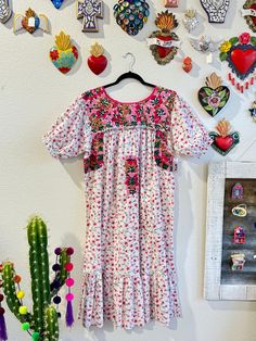 Our San Antonino dresses are unique, beautiful and perfect for any fiesta, a day at the beach or a formal event. You can easily dress it up or dress it down. Our dresses are completely hand embroidered by Artisans in Oaxaca, Mexico. It takes approximately 1 month to complete one dress.  Our San Antonino dresses are one of a kind. You will fall in love with every single detail. Each dress is hand embroidered on front chest area, sides and back with tiny floral designs inspired by the flowers in t Spring Fiesta Dress With Embroidered Hem, Pink Ruffled Dress For Festival, Embroidered Dresses For Spring Fiesta, Spring Fiesta Dress With Multicolor Embroidery, Multicolor Embroidered Floral Print Short Sleeve Dress, Short Sleeve Floral Print Dress With Multicolor Embroidery, Multicolor Embroidery Floral Print Dress For Vacation, Pink Embroidered Ruffle Dress For Summer, Bohemian Pink Midi Dress With Floral Embroidery