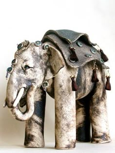 an elephant statue made out of cement with beads on it's tusks