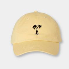 a yellow hat with two palm trees embroidered on the front and back, against a white background