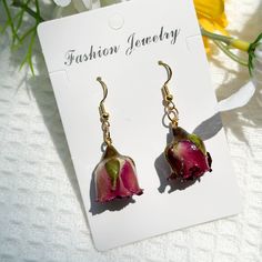 a pair of earrings with pink flowers on them