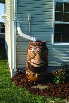 a large tiki style water heater sitting in the grass next to a house