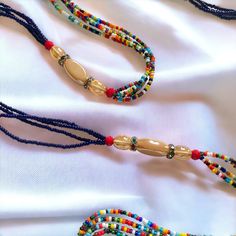 **DRIP FAIRY IS CURRENTLY OPEN FOR PRE-ORDERS ONLY! ALL ORDERS WILL NOT BE SHIPPED OUT UNTIL FEBRUARY 24, 2024. AS A THANK YOU TO THOSE PRE-ORDERING THESE ORDERS WILL ALSO INCLUDE A FREE GIFT! This handmade Ivorian waist bead has an incredibly beautiful four strand design in the colors of purple, gold, and red. Each waist bead is carefully crafted using a combination of strong threads woven together to create a durable and long-lasting piece. The beads themselves are made from glass and each one is carefully chosen to ensure a consistent look and feel to the waist bead. Crafted using high-quality materials, this waist bead is durable and designed to last. The strands provide a comfortable and secure fit, while the adjustable length ensures that it can fit a wide range of waist sizes. The p Bohemian Handmade Beaded Necklaces For Traditional Ceremonies, Multi-strand Beaded Waist Beads For Festival, Handmade Red Beaded Necklaces For Traditional Ceremonies, Traditional Beads For Beach Festivals, Colorful Traditional Beaded Necklaces For Ceremonies, Colorful Heishi Beads For Festival, Traditional Colorful Beaded Necklaces For Ceremonies, Multi-strand Beaded Bracelets With Large Beads For Festivals, Handmade Adjustable Oval Waist Beads