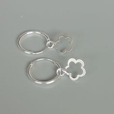 A PAIR of sterling silver hoops. Comes with a detachable cut out flower charm. The charm is multipurpose and can be used with a neck or bracelet chain too. Dimension: Hoop- 15 x 1.5 mm Charm: 10 x 12 mm Drop length- 23 mm These earrings are made of 925 hypoallergenic sterling silver and plastic. Please note this price is for ONE PAIR. All my pieces are sent in a gift box. I can include a personal message from you if needed You are welcome to contact me at... bhavnakwintra1956@gmail.com For more Gift Huggie Hoop Earrings With Flower Charm, Flower Charm Huggie Earrings As Gift, Huggie Jewelry With Flower Charm For Gift, Gift Jewelry Flower Charm Huggie, Huggie Jewelry With Flower Charm As Gift, Silver Dangle Hoop Earrings With Charms, Small Hoop Jewelry With Flower Charm For Everyday, Small Hoop Jewelry With Flower Charm For Gifts, Silver Huggie Earrings With Charms In Small Hoop Shape