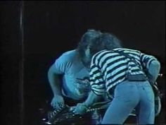 two men in striped shirts playing guitars on stage