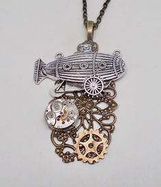 "Awesome steampunk necklace made of airship charm, watch movement and brass gears mounted on Victorian filigree . The size is 2\" by 2 1/2\" and it has 24\" antique brass chain. All my jewelry come in a nice gift box. More steampunk necklaces in my shop www.etsy.com/shop/slotzkin" Steampunk Jewelry With Vintage Charm, Steampunk Bronze Pendant Necklace, Steampunk Metal Necklaces With Antique Finish, Steampunk Antique Gold Metal Necklaces, Steampunk Brass Necklaces For Gifts, Handmade Steampunk Brass Necklaces, Steampunk Bronze Nickel-free Necklace, Handmade Steampunk Brass Necklace, Antique Gold Steampunk Brass Necklace