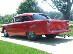 an old red car is parked on the sidewalk