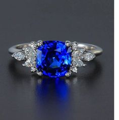 a blue sapphire and diamond ring on a black surface