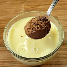 a spoon in a glass bowl filled with milk and chocolate powder on top of it