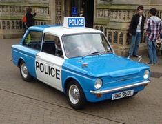 an old police car parked in front of a building