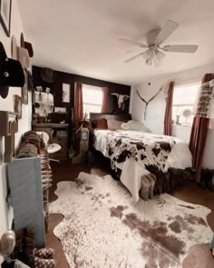 a bed room with a neatly made bed and cow hide rugs on the floor