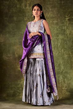 Grey printed kurta highlighted with dori and zardozi work. Paired with printed gharara and purple dupatta.
Component: 3
Pattern: Printed,Embroidered
Type Of Work: Dori and Zardozi Work
Neckline: Round
Sleeve Type: Sleeveless
Fabric: Chanderi Silk, Organza Silk
Color: Grey
Other Details: 
Purple dupatta
Tiered sharara
Embroidered bodice
Occasion: Wedding - Aza Fashions Silk Gharara Designs, Indian Sharara, Gharara Designs, Punit Balana, Pink Anarkali, Kurta Sharara Set, Kurta Sharara, Anarkali Dress Pattern, Indian Wedding Photos