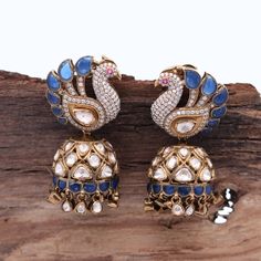 Our breathtaking Peacock Motif Statement Earring, adorned with fine quality Moissanite and a captivating Blue stone that exudes elegance and sophistication. Meticulously crafted in 925 Silver, this earring mirrors the authenticity of Indian Polki style, accentuated by high carat gold-plated silver. The omega hook and push-back closure ensure a secure and robust stud, making it an exquisite choice for weddings or evening soirees. Elevate your festive ensemble or gift this remarkable Diwali present to yourself or a loved one. Gross Weight: 43.78 gms Dimensions: 52 x 25mm Explore more exquisite pieces at our [Etsy Shop](https://www.etsy.com/in-en/shop/TempusGems). Explore more in our shop: [TempusGems](https://www.etsy.com/in-en/shop/TempusGems) Packaging and Shipping We take great care to en Festive Peacock Design Earrings For Reception, Elegant Sterling Silver Earrings With Peacock Design, Peacock Colored Jewelry For Weddings And Festivals, Traditional Diamond Jewelry With Peacock Design, Diamond Earrings With Latkans For Diwali, Elegant Peacock Earrings For Wedding, Formal Peacock Design Drop Earrings, Elegant Chandbalis With Peacock Design For Diwali, Elegant Peacock Colored Earrings For Wedding