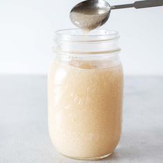 a spoon in a glass jar filled with liquid