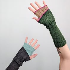 two hands wearing knitted mittens reaching up towards each other