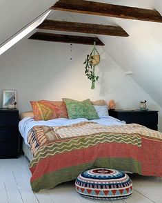 a bedroom with white walls and wooden beams