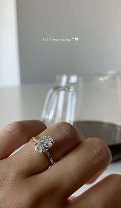 a person's hand holding a diamond ring