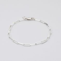 Sterling Silver bracelet on grey background Classic Silver Chain Bracelet For Everyday, Sterling Silver Bracelet With Silver Chain For Everyday Wear, Modern White Gold Paperclip Bracelet, Sterling Silver Chain Bracelet For Everyday, Classic Sterling Silver Bracelet With Silver Chain For Everyday, Sterling Silver Bracelet With Solid Links For Everyday Wear, Sterling Silver Everyday Bracelet With Solid Chain Link, Trendy Sterling Silver Chain Link Bracelet, Classic Everyday Sterling Silver Bracelet With Silver Chain