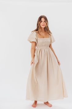 Be the life of the party in the Nan Maxi Dress! This beautiful gown comes in a gorgeous, multi-season neutral hue, and features a smocked bodice and puffed sleeves that can be worn on or off the shoulder - it's like getting two dresses in one! Style the Nan with slides for a casual, feminine outfit, or with neutral heels for the perfect event dress. FIT: Runs true to size. MATERIAL: GARMENT DETAILS: Neutral maxi dress with empire waist silhouette, smocked bodice, and puffed sleeves with elastica Puff Sleeve Midi Dress For Garden Party, Puff Sleeve Dress With Smocked Back For Garden Party, Garden Party Puff Sleeve Dress With Smocked Back, Garden Party Puff Sleeve Dress With Ruched Bodice, Garden Party Dress With Puff Sleeves And Ruched Bodice, Spring Puff Sleeve Dress For Gatherings, Flowy Smocked Bodice Puff Sleeve Dresses, Elegant Dress With Smocked Back And Bishop Sleeves, Flowy Ruched Puff Sleeve Dress For Garden Party