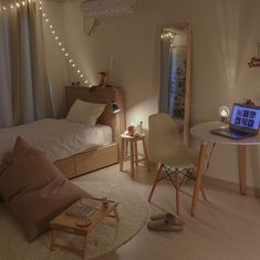 a bedroom with a bed, desk and laptop on the table in front of it