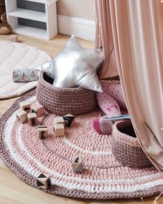 a crocheted round rug with wooden blocks on the floor