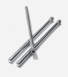 three stainless steel rods on a white surface