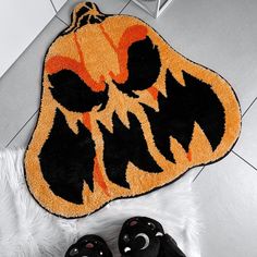 a black and orange rug with an angry pumpkin on it