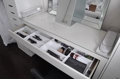 a white vanity with drawers and mirrors