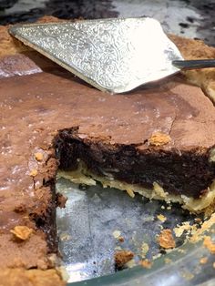 a chocolate pie with a slice missing from it and a spatula in the background