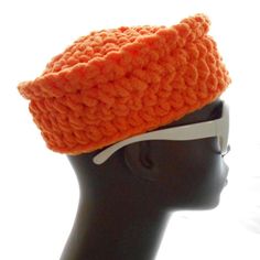 a mannequin head wearing an orange crochet hat with white visor