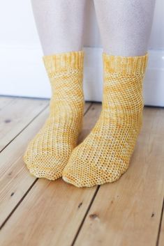 a person wearing yellow socks standing on a wooden floor