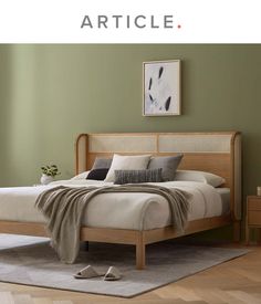 a bed sitting on top of a wooden floor next to a green wall