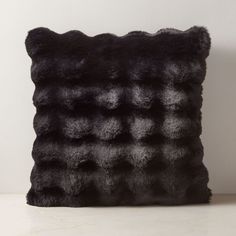 a black furry pillow sitting on top of a table