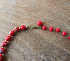 "Vintage glass bead necklace/choker, glass beads are descending in size and are hand knotted between each. Each bead has colorful striped \"balls\" on them that look like little sea urchins. Circa 1940's - 50's (possibly earlier), marked Japan on hook clasp. Largest bead is approx. 3/4\". Necklace is in good condition, please see photos. Offbeat Avenue uses recycled packaging when available." Retro Wooden Bead Jewelry, Retro Wooden Round Bead Jewelry, Vintage Beads For Jewelry Making, Adjustable Vintage Beads For Jewelry Making, Vintage Adjustable Faceted Beads, Vintage Adjustable Beaded Necklace With Faceted Beads, Adjustable Vintage Beaded Necklace With Faceted Beads, Vintage Adjustable Necklaces With Colorful Beads, Vintage Czech Glass Beaded Necklaces With Round Beads