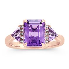 One emerald cut amethyst gemstone (approx. 2.14 carats) highlights this exquisite ring. Two trillion amethyst gemstones (approx. .35 carat TW)  and 10 round diamonds (approx. .05 carat TW) make brilliant accents. Crafted from quality 14 karat rose gold  this bold ring measures 2mm at the band and has a total gem weight of approximately 2.54 carats. Mafia Princess, Michael Hill, Amethyst And Diamond Ring, Princess Luna, Bold Rings, Platinum Jewelry, Natural Diamond Ring, Stylish Rings, Amethyst Necklace