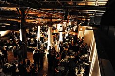 a group of people standing around in a room with lots of lights on the ceiling