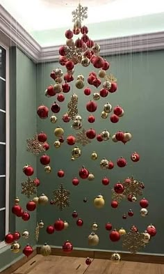 a christmas tree made out of red and white ornaments hanging from it's ceiling