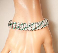 "Offering an absolutely stunning high quality vintage Art Deco unsigned \"CINER\" (Emanual Ciner) emerald green and brilliantly clear crystal rhinestone wide link bracelet.  The shiny silver rhodium plated bracelet features slightly domed chevron shaped links that are set with alternating rich emerald green accents as well as brilliantly clear sparkly crystal rhinestones. The bracelet is raised up a tad in the center creating even more interest and sparkle.  This bracelet absolutely glimmers! It Green Rhinestone Bracelets For Wedding, Green Costume Jewelry Bracelets For Wedding, Emerald Green Accents, Vintage Rhinestone Jewelry, 1920s Wedding, Myrna Loy, Art Deco Bracelet, Rhinestone Art, Something Old