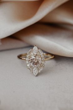 a diamond ring sitting on top of a white cloth