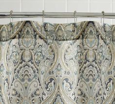 a curtain with an ornate pattern hanging from a metal rod