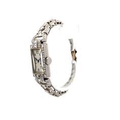 This antique Art Deco manual wind diamond watch, made from polished 14 karat white gold, features .60 carats of asscher cut diamonds with VS1 clarity and H color grade. Surrounding it are accent diamonds in various cuts, including old European, baguette, and single cuts, all bezel or channel set. These diamonds, ranging in size from 2.75 mm to 2.15 mm, contribute an additional .35 carats. The watch also showcases intricate milgrain detailing and engraving on the case, along with tapered links for added comfort. This vintage-inspired timepiece combines functionality with a rich sense of history. Engagement Ring Style Guide, Ring Style Guide, Platinum Rose Gold, Asscher Cut Diamond, Sapphire Solitaire, Asscher Cut, Art Deco Diamond, Channel Set, Engagement Ring Styles