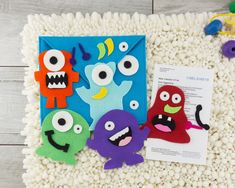 an envelope decorated with paper cut outs and monster faces on top of white cotton balls