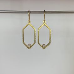 These modern gold frames cradling sparkling diamonds are ready for any party. 18k yellow gold Diamonds (3mm in diameter) Earrings are 1/2" wide and hang 2 3/16" Each earring weighs 2.8g Oval Gold Diamond Earrings, Dangle Yellow Gold Diamond Hoop Earrings, Gold Oval Diamond Earrings For Gift, 14k Gold Halo Design Drop Earrings, Gold Oval Diamond Earrings, Gold Dangle Hoop Earrings With Halo Design, 14k Gold Diamond White Pierced Earrings, Gold Diamond-cut Diamond Earrings, Gold Diamond-cut Earrings