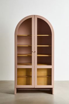 a pink bookcase with yellow shelves on the top and bottom, in front of a white wall