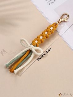 an orange and white keychain with two tassels on it's end